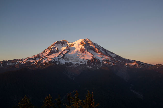 Sunset paints the glaciers of Mount Rainier in pink and gold.