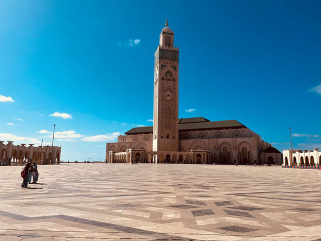 Hassan II Mosque against a blue sky in Casablanca, showcasing stunning Islamic architecture.