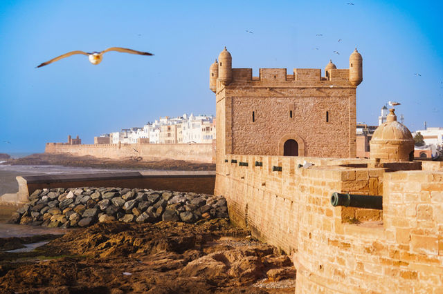 A picturesque view of Essaouira's ancient fortification walls by the sea, highlighting its historic charm.