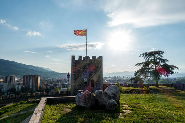 The flag of North Macedonia flying over the capital of Skopje.