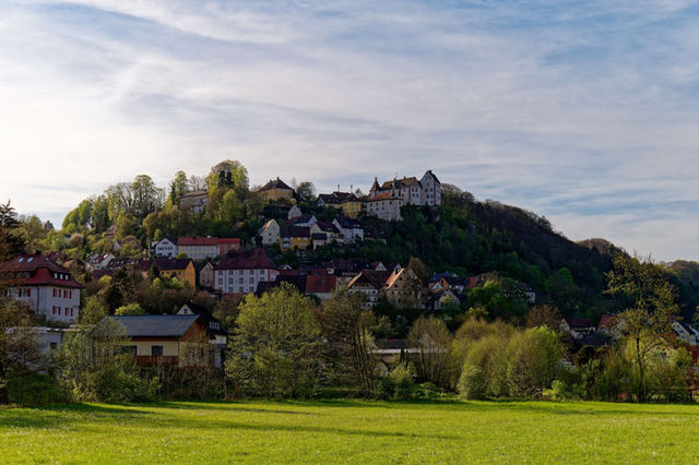 Picturesque hillside village of Egloffstein in Bavaria, Germany, surrounded by lush greenery.