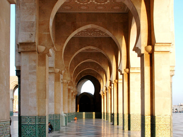 Beautiful ornamented arches in a mosque's corridor, capturing Casablanca's architectural elegance.