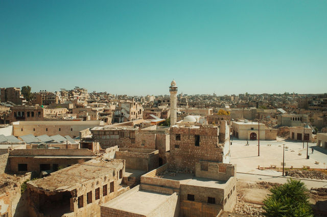 View of Aleppo city showcasing ancient architecture under a clear blue sky.