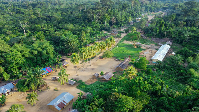 Aerial view of a flooded village surrounded by lush jungle