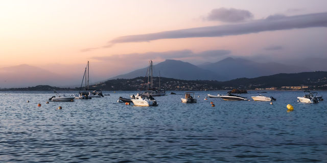 Peaceful evening scene of boats floating in Ajaccio Bay, Corsica, France.