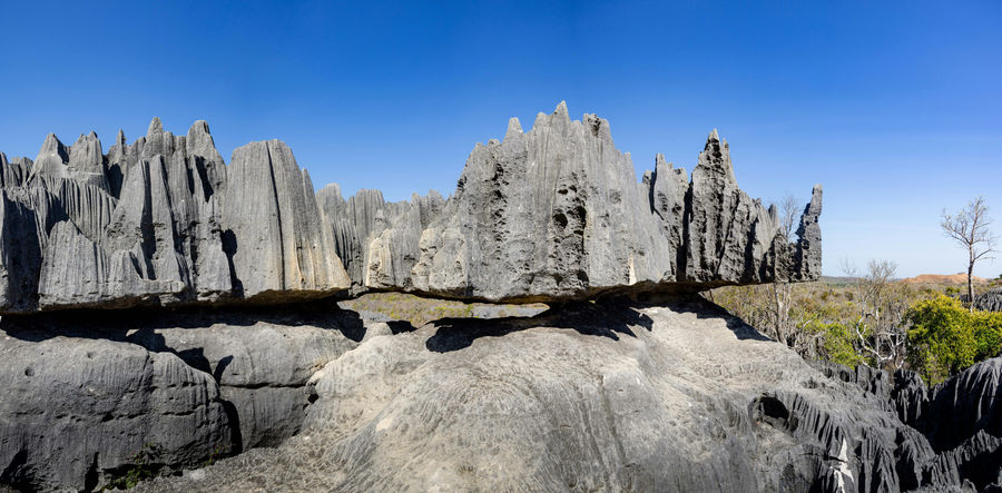 Sharp, jagged grey rock formations under a clear blue sky.