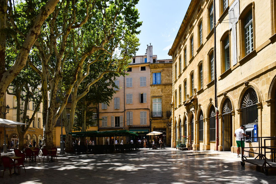 A sunny day in Aix-en-Provence showcasing historic architecture and lush trees.