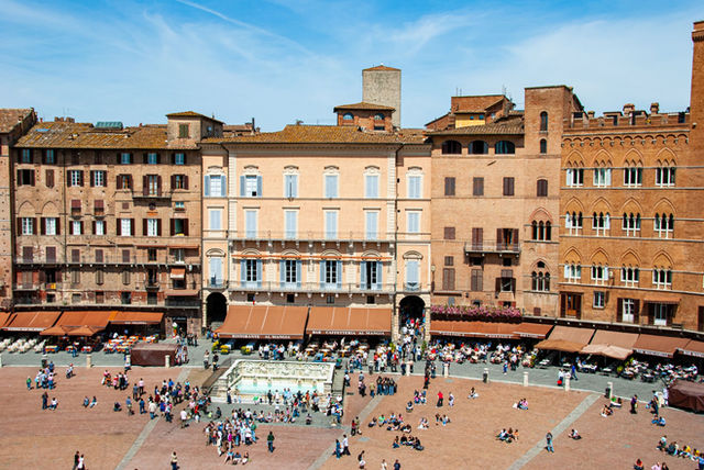 Lively Piazza del Campo with historic buildings and bustling crowds in Siena, Tuscany.