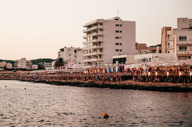 Lively Ibiza waterfront scene showcasing vibrant coastal nightlife at sunset.
