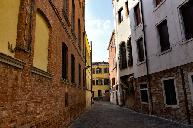 Picturesque alley with colorful townhouses in Venice, Italy.
