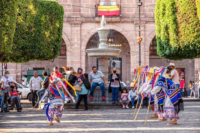 Colorful traditional dance performance in the busy town square of Morelia, Mexico.