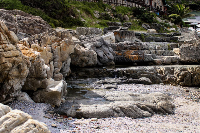 Natural rock formations with unique textures by the coast in Hermanus, South Africa.