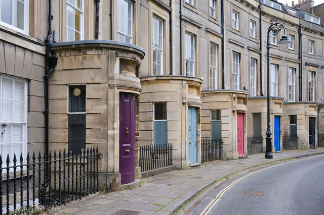 Charming Georgian terraced houses with colorful doors in Bath, England.