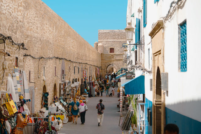 Explore the vibrant souk in Essaouira, Morocco, with colorful shops and historic architecture.