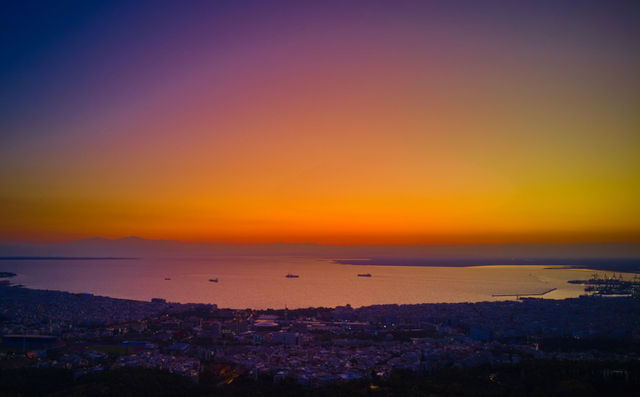 The aerial view photo of Thessaloniki at sunset is a breathtaking sight, showcasing the city in all its glory as the warm, golden light of the setting sun illuminates its ancient and modern buildings.