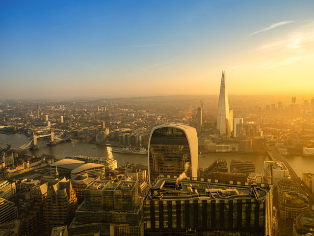 A breathtaking aerial view of London's skyline featuring the Shard and Tower Bridge during sunset.
