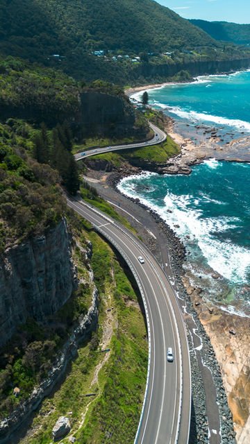 an aerial view of a highway next to the ocean