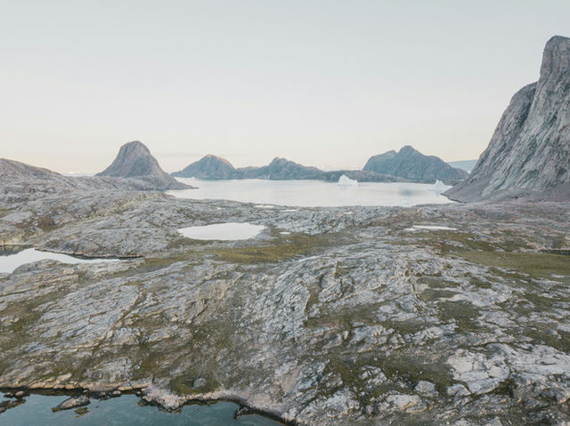 an aerial view of a mountain range with a body of water in the foreground