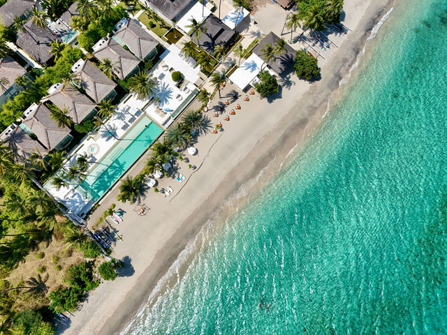Aerial shot of a luxury resort with beachfront view and turquoise waters in Lombok, Indonesia.