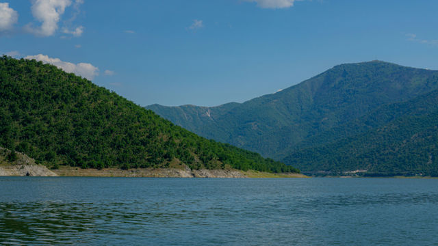 A body of water with mountains in the background