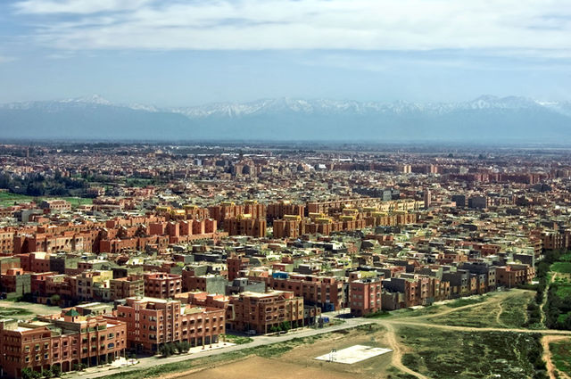 Stunning aerial view of Marrakech cityscape with Atlas Mountains in the background.