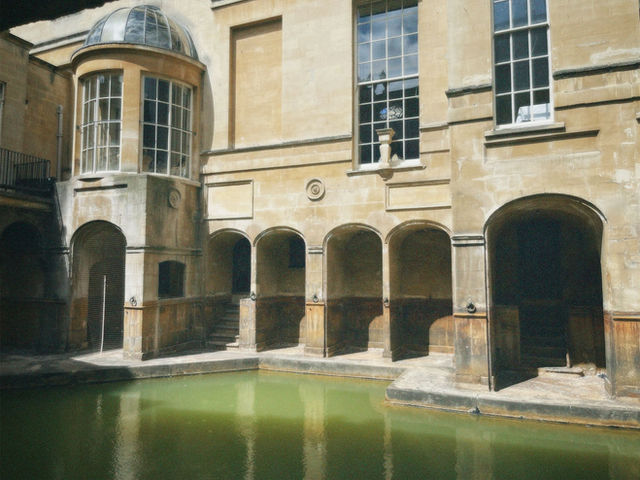 Capture the ancient Roman Baths' stunning architecture in Bath, England with natural lighting and historic allure.