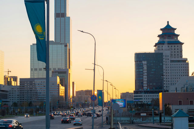 a city street filled with lots of traffic next to tall buildings