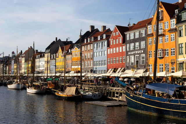 Colorful buildings line a canal with boats in copenhagen
