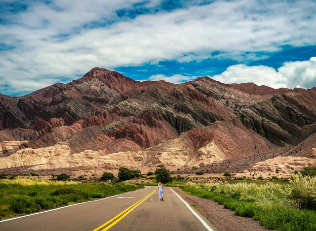 gray asphalt road in between brown mountains under blue sky during daytime