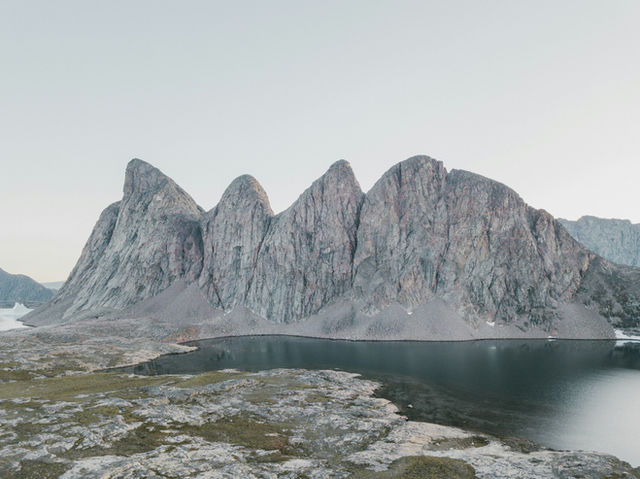 a mountain range with a lake in the foreground