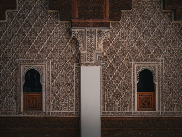 Detailed Islamic geometric patterns on an ornate wall in Marrakech, Morocco.