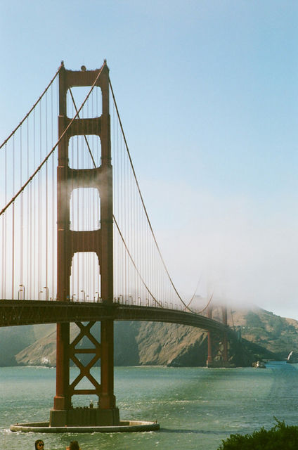 The golden gate bridge with fog rolling over the hills