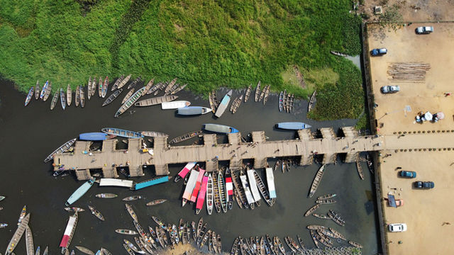 Aerial shot of the Ganvié pier with numerous boats moored in Benin.