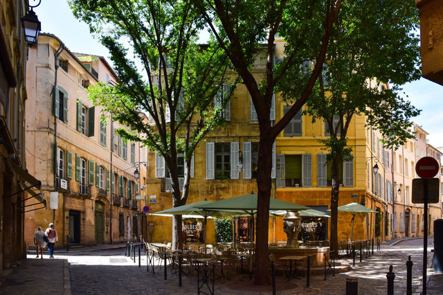 Picturesque street corner in Aix-en-Provence, showcasing traditional architecture and vibrant outdoor café setting.