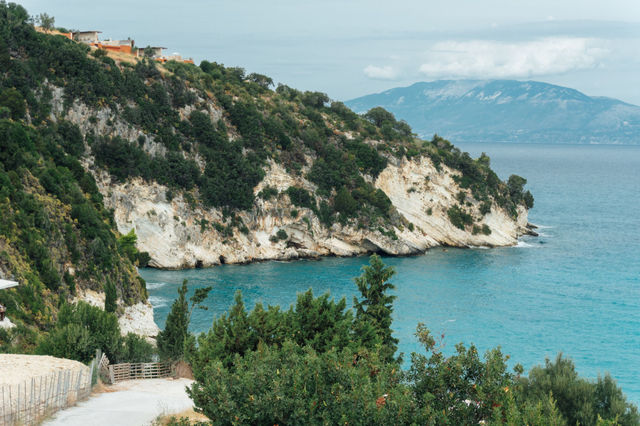 Stunning cliffside view of Zakynthos coastline with turquoise waters and lush greenery.
