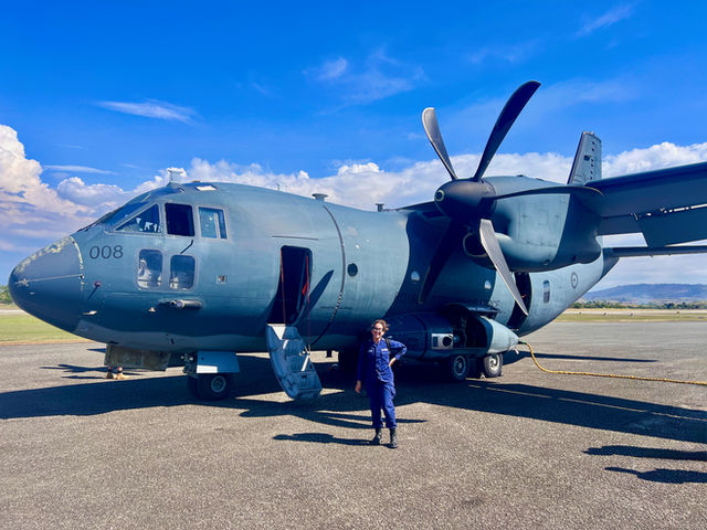 Petty Officer 2nd Class Nathalie Aviles stands with a Royal Australian Air Force C-27J Spartan airplane in Honiara, Solomon Islands, following a flight on Aug. 12, 2025. Aviles pla