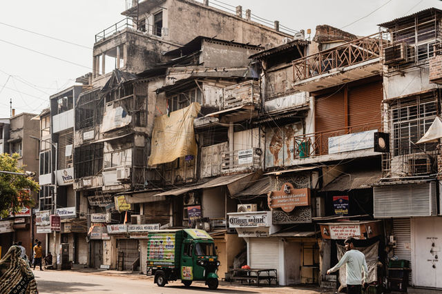 Urban scene in Ahmedabad with vintage buildings and auto rickshaw.
