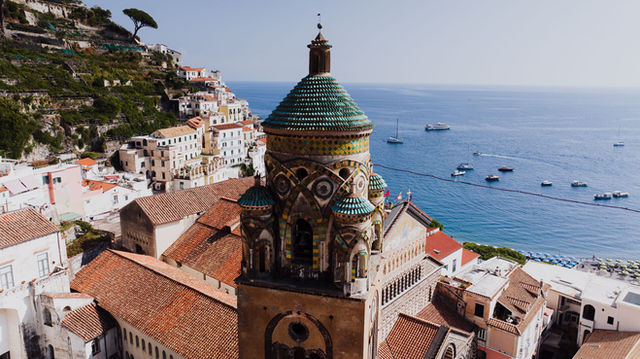 A picturesque view of Amalfi's church tower with the stunning Mediterranean backdrop.