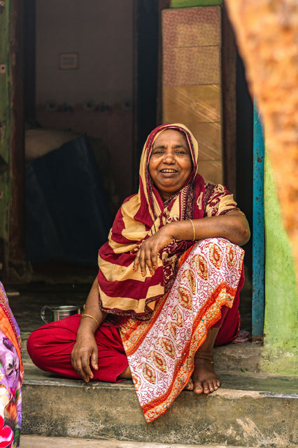 A shopkeeper smiles from her doorway