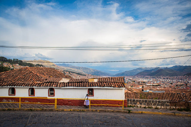 Explore Cusco's scenic cityscape with traditional rooftops and expansive mountain views.