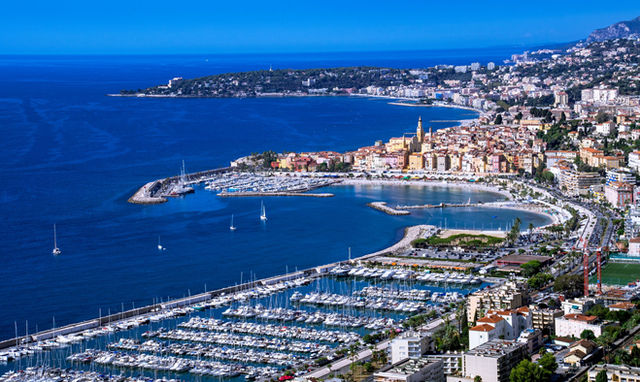 Explore the stunning aerial view of Menton with vibrant architecture along the French Riviera's coastline.