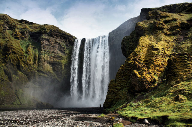 A majestic waterfall cascades down mossy cliffs