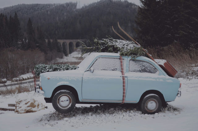 A small car with a christmas tree on top of it