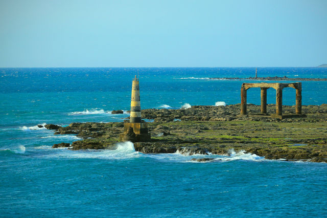 a large body of water next to a rocky shore