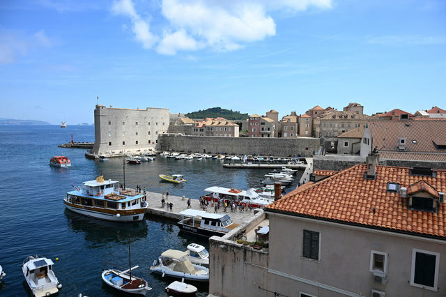 Boats gather in Dubrovnik's historic Old Port beneath centuries-old stone fortifications, where the Adriatic Sea meets one of Croatia's most iconic coastal cities.