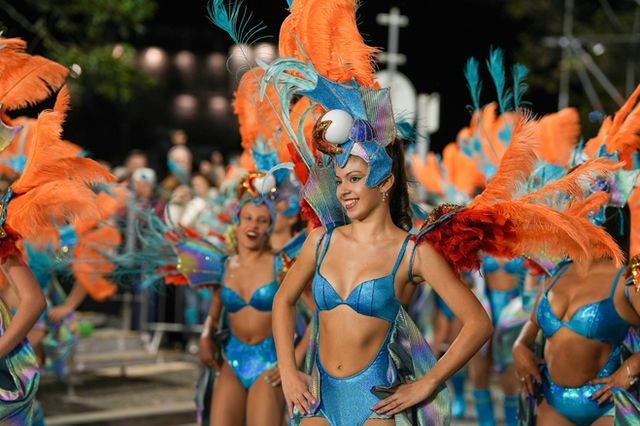 Dancers in rank, colour running the length of the parade