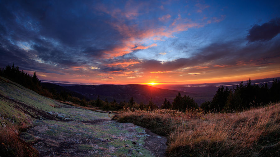 A brilliant sunset filled with hues of blue, red, orange, magenta, and purple highlight the sky.
