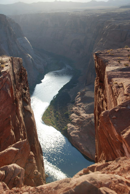 A winding river flows through a rocky canyon under sunlight