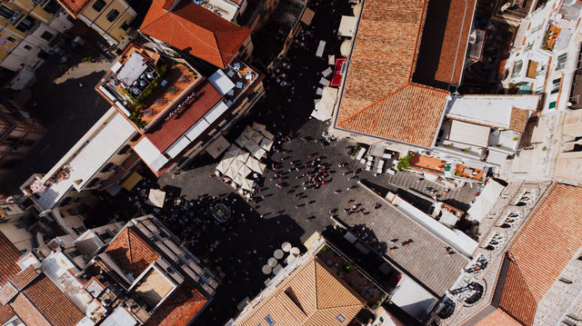 Stunning aerial view of a busy town square in Amalfi, Italy with vibrant rooftops.