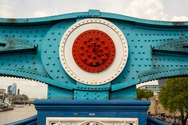 Close-up of colorful design elements on Tower Bridge, London with cityscape in the background.
